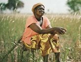 A woman sitting in a field on a sunny day
